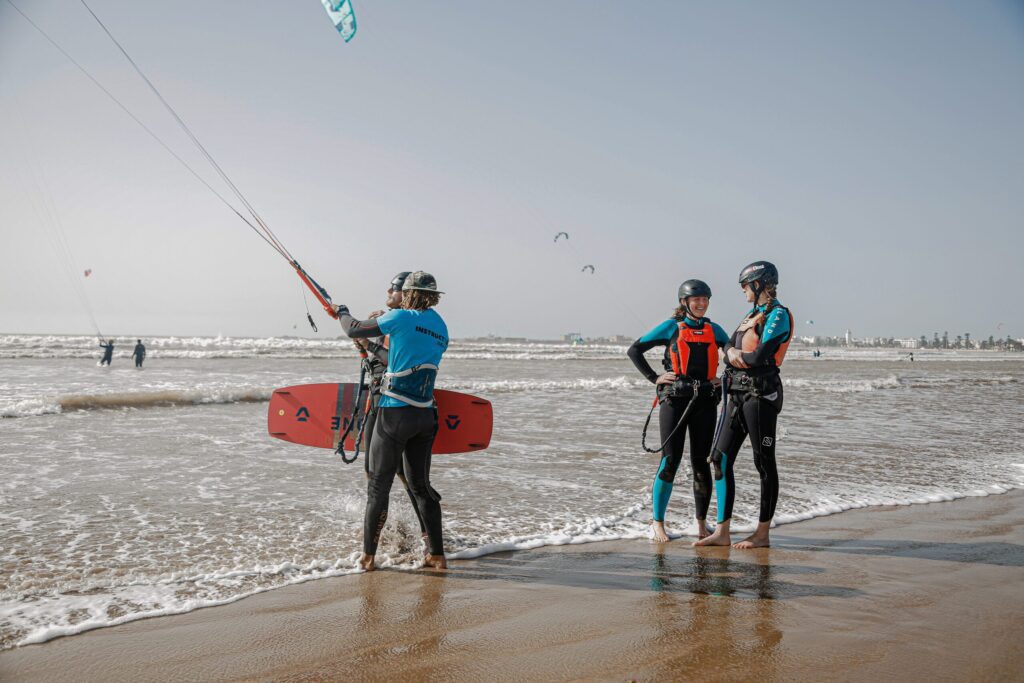 Kitesurf instructor briefing two students on the shore before entering the water in Essaouira